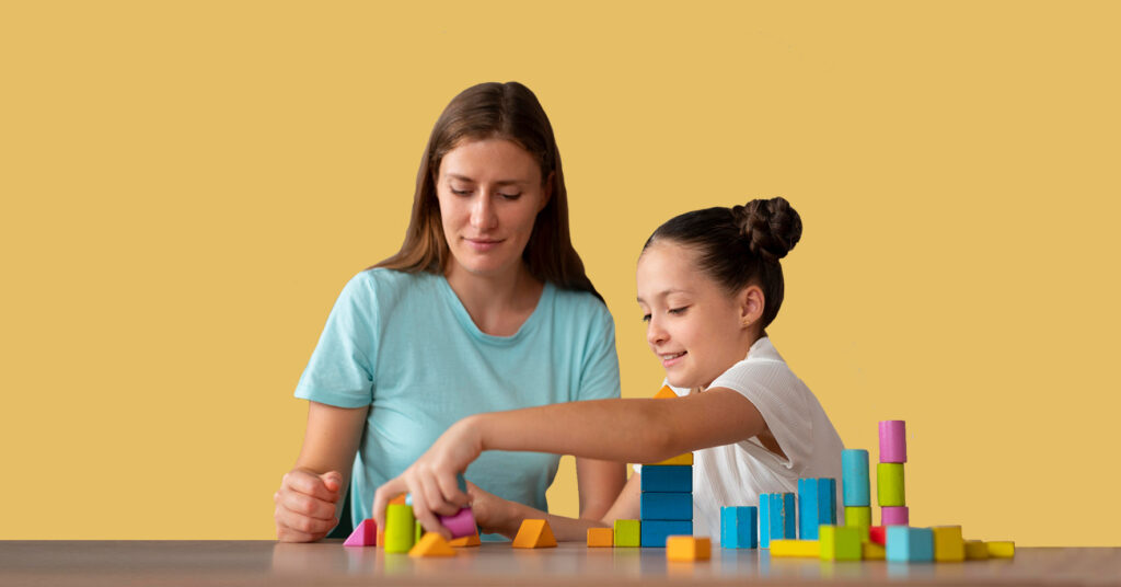 Therapist and girl using blocks in ABA therapy session